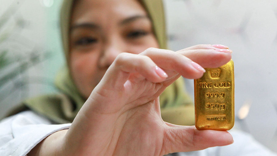 Karyawati memperlihatkan emas logam mulia Antam di Butik Emas ANTAM, Jakarta, Selasa (16/72024). (Bloomberg Technoz/Andrean Kristianto)
