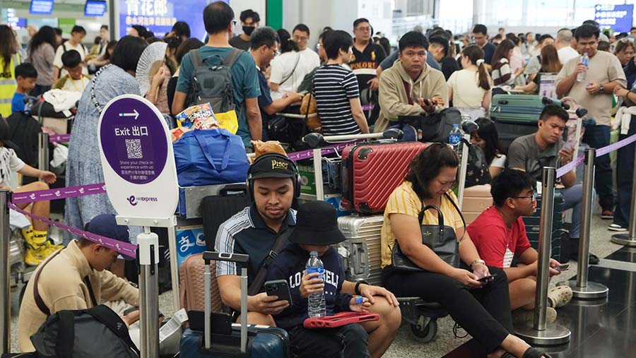 Penumpang mengantre di konter check-in saat gangguan sistem Microsoft di Bandara Internasional Hong Kong, Jumat (19/7/2024). (Yik Yeung-man/Bloomberg)