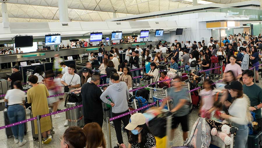 Penumpang mengantre di konter check-in saat gangguan sistem Microsoft di Bandara Internasional Hong Kong, Jumat (19/7/2024). (Yik Yeung-man/Bloomberg)