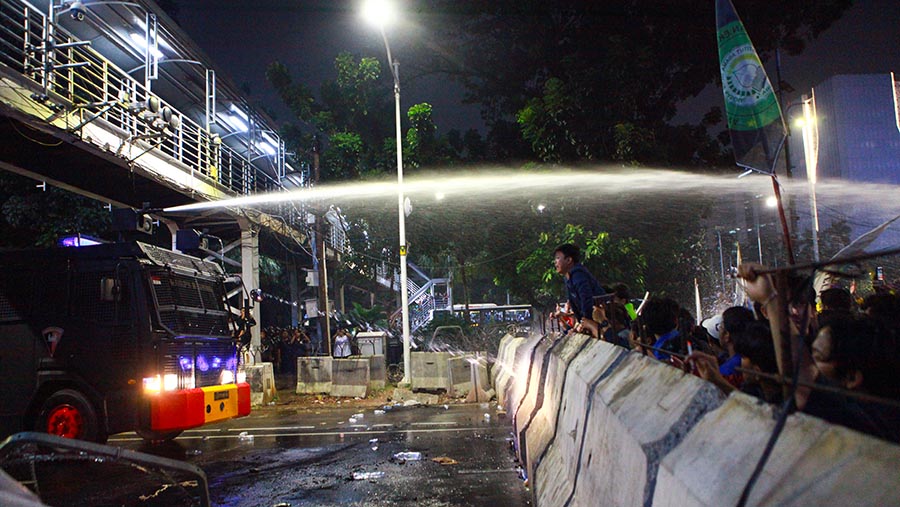 Polisi menggunakan water canon untuk membubarkan massa aksi, (Bloomberg Technoz/Andrean Kristianto)