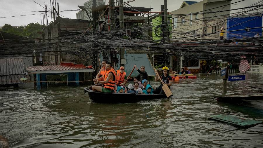 Warga terjebak banjir yang disebabkan oleh Topan Gaemi di kota Quezon, Metro Manila, Filipina, pada 24 Juli. (Dok: Ezra Acayan/Getty Images)