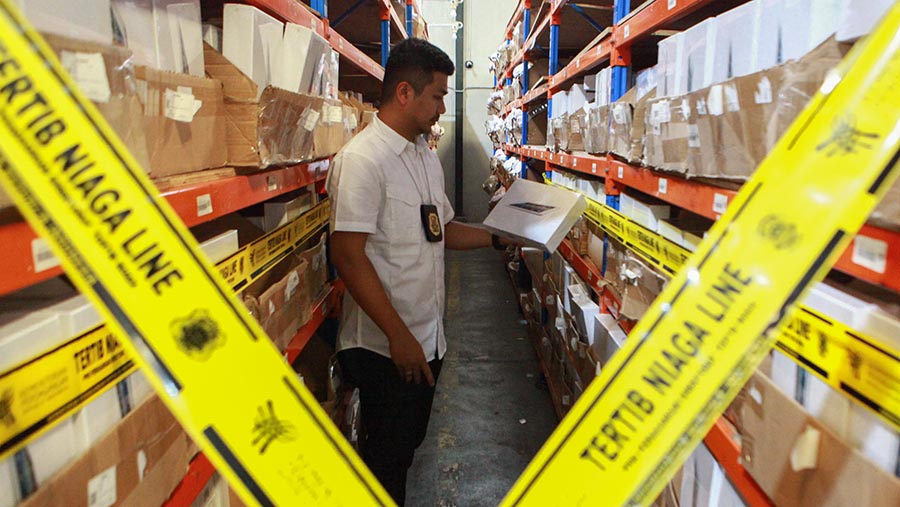 Petugas memeriksa gudang barang impor ilegal di Kamal Muara, Jakarta Utara, Jumat (25/7/2024). (Bloomberg Technoz/Andrean Kristianto)