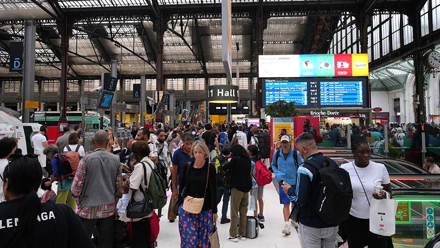 Penumpang menunggu kereta api selama gangguan layanan di Stasiun Gare de Lyon di Paris, Prancis, Jumat (26/7/2024). (Nathan Laine/Bloomberg)