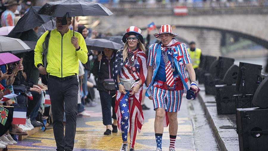 Penonton dengan pakaian bertema bendera Amerika saat upacara pembukaan Olimpiade Paris 2024 di Paris, Jumat (26/7/2024). (Nathan Laine/Bloomberg)