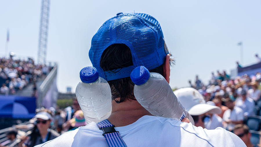 Penonton menaruh botol air dingin saat cuaca panas di stadion Concorde Olimpiade Paris 2024 di Paris, Prancis, Selasa (30/7/2024). (Nathan Laine/Bloom