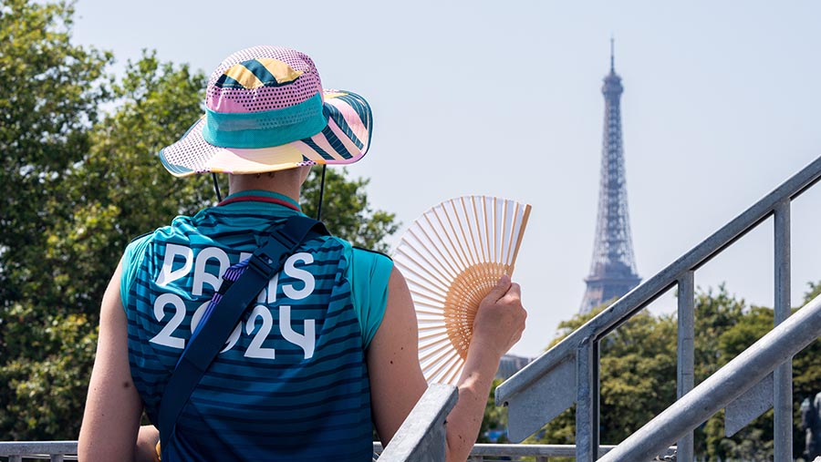 Seorang relawan menggunakan kipas tangan di stadion Concorde Olimpiade Paris 2024 di Paris, Prancis, Selasa (30/7/2024). (Nathan Laine/Bloomberg)