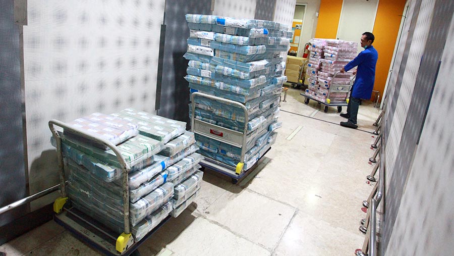 Petugas memindahkan tumpukan uang rupiah di salah satu bank di Jakarta, Kamis (1/8/2024). (Bloomberg Technoz/Andrean Kristianto)