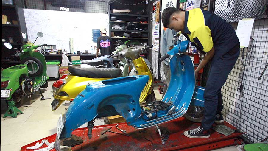 Pekerja meakukan pengerjaan konversi motor listrik di Elders Garage, Jakarta, Jumat (2/8/2024).  (Bloomberg Technoz/Andrean Kristianto)