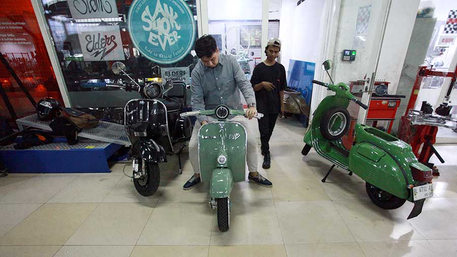 Karyawan mencoba Vespa yang telah dikonversi menjadi motor listrik di Elders Garage, Jakarta, Jumat (2/8/2024). (Bloomberg Technoz/Andrean Kristianto)