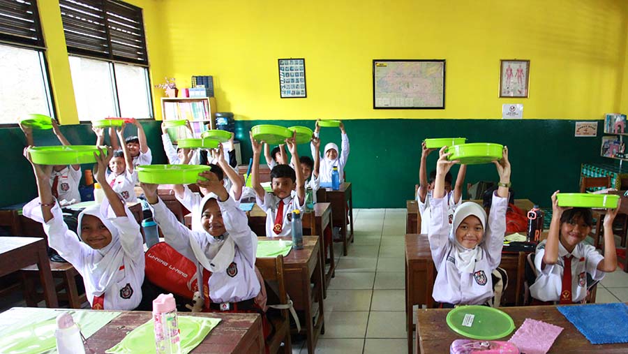 Siswa menyantap makanan saat uji coba program makan siang gratis di SDN 4 Tangerang, Senin (5/8/2024). (Bloomberg Technoz/Andrean Kristianto)