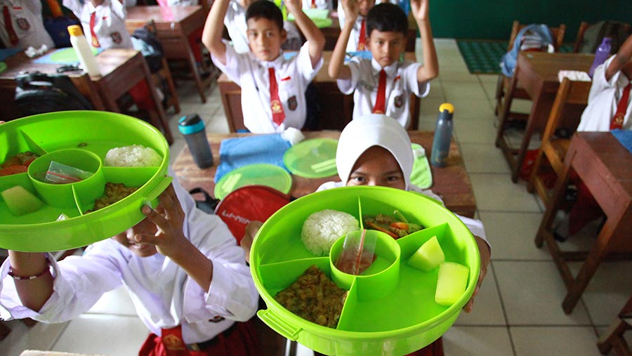 Siswa menyantap makanan saat uji coba program makan siang gratis di SDN 4 Tangerang, Senin (5/8/2024). (Bloomberg Technoz/Andrean Kristianto)
