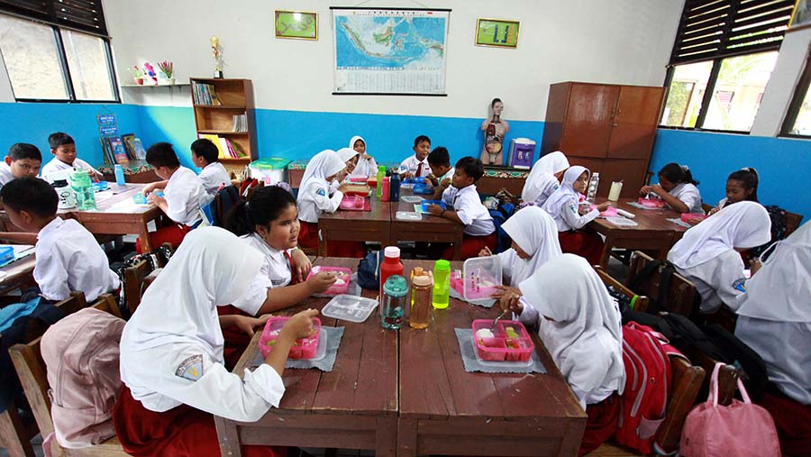 Siswa menyantap makanan saat uji coba program makan siang gratis di SDN 4 Tangerang, Senin (5/8/2024). (Bloomberg Technoz/Andrean Kristianto)
