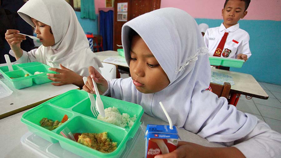 Siswa menyantap makanan saat uji coba program makan siang gratis di SDN 4 Tangerang, Senin (5/8/2024). (Bloomberg Technoz/Andrean Kristianto)