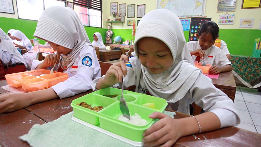 Siswa menyantap makanan saat uji coba program makan siang gratis di SDN 4 Tangerang, Senin (5/8/2024). (Bloomberg Technoz/Andrean Kristianto)