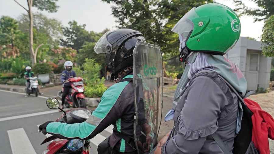 Mitra pengemudi atau driver ojol antarkan penumpang. (Dimas Ardian/Bloomberg)	
