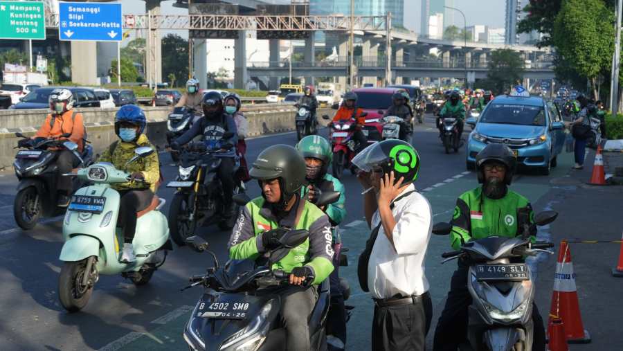 Mitra pengemudi atau driver ojol menurunkan penumpang. (Dimas Ardian/Bloomberg)	
