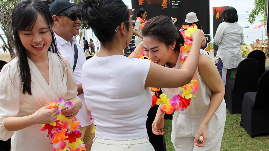 Para peserta mendapatkan kalung bunga dan langsung menuju pantai. (Bloomberg Technoz/Andrean Kristianto)