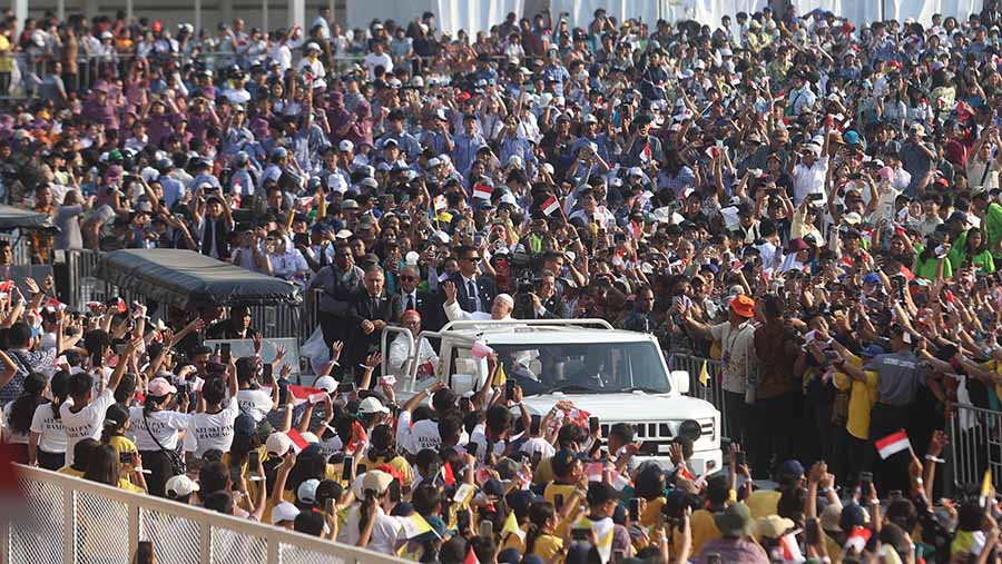 Paus Fransiskus terlihat hadir menggunakan mobil terbuka dan disambut ribuan jemaat yang hadir. (INDONESIA PAPAL VISIT COMMITTEE/HENDRA A SETYAWAN)