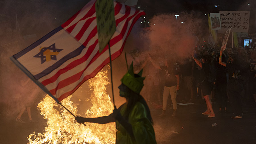 Warga Israel berunjuk rasa di sekitar api unggun selama demonstrasi di Tel Aviv, Israel, Sabtu (7/9/2024). (David Lombeida/Bloomberg)