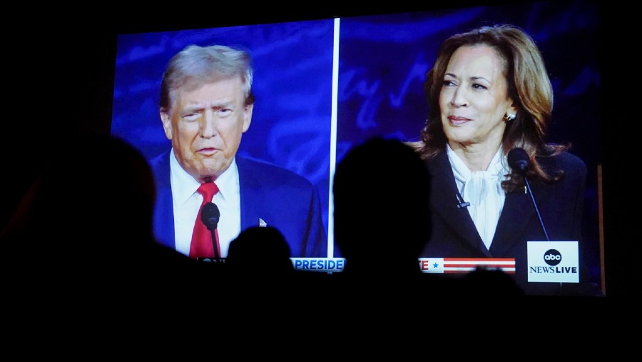 Donald Trump & Kamala Harris ditampilkan di layar saat debat di Cameo Art House Theatre, AS (10/9/2024). (Dok: Allison Joyce/Bloomberg)