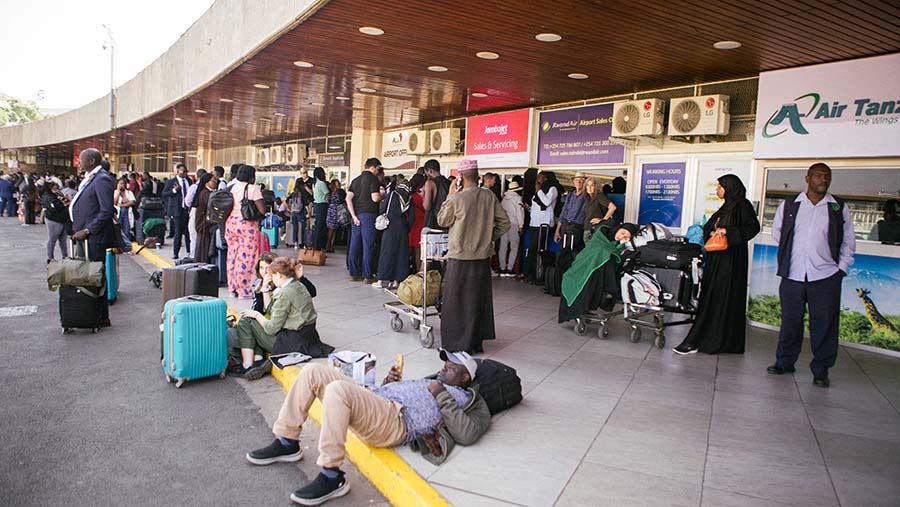 Penumpang yang terdampar terlihat berkumpul di terminal bandara, menunggu kabar terkait penerbangan mereka. (Kang-Chun Cheng/Bloomberg)