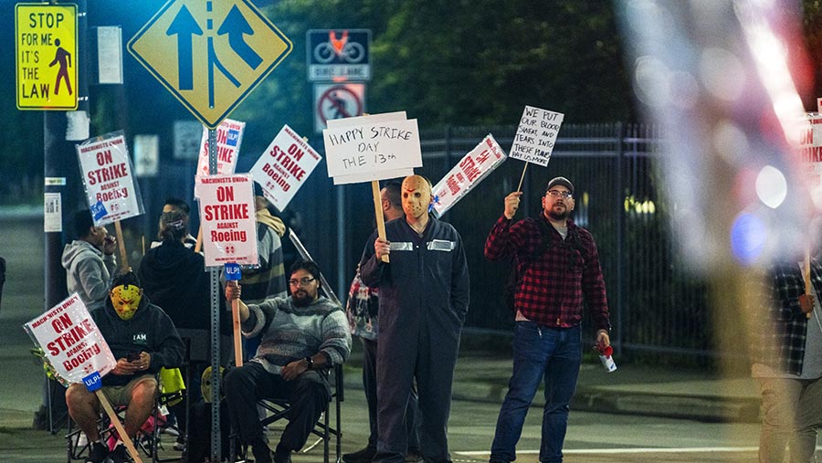 Pekerja membawa poster saat aksi mogok di luar fasilitas manufaktur Boeing di Renton, Washington, AS, Jumat (13/9/2024). (M. Scott Brauer/Bloomberg)