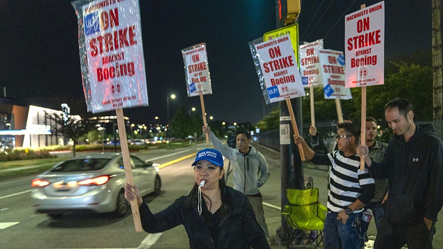 Pekerja membawa poster saat aksi mogok di luar fasilitas manufaktur Boeing di Renton, Washington, AS, Jumat (13/9/2024). (M. Scott Brauer/Bloomberg)