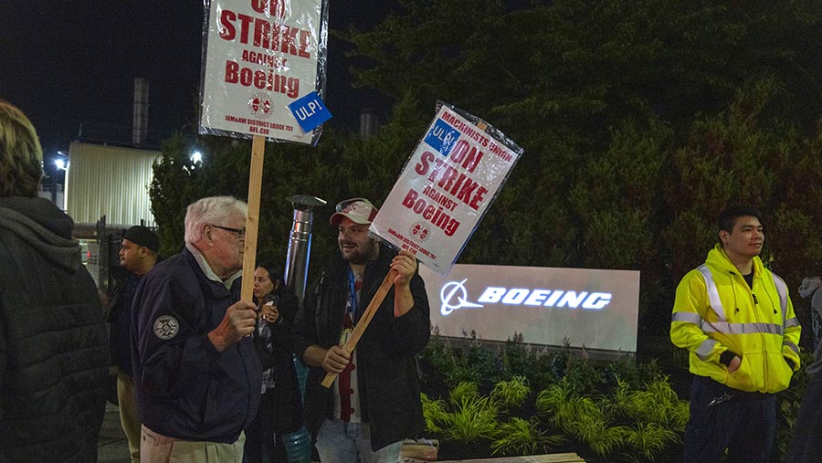 Pekerja membawa poster saat aksi mogok di luar fasilitas manufaktur Boeing di Renton, Washington, AS, Jumat (13/9/2024). (M. Scott Brauer/Bloomberg)