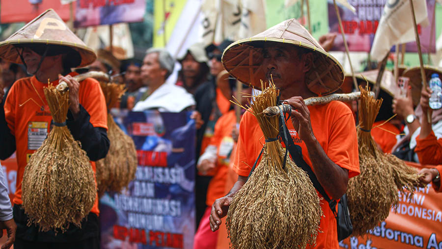 Dalam aksinya petani membawa traktor hingga menggenggam gabah kering menuntut komitmen reforma agraria.  (Bloomberg Technoz/ Andrean Kristianto)