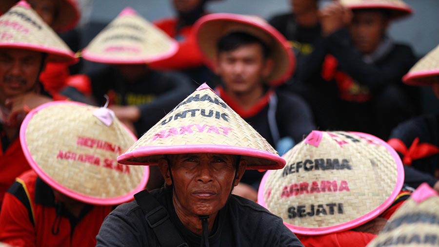 Mayoritas massa terlihat memakai baju merah dan hitam serta menggunakan caping. (Bloomberg Technoz/ Andrean Kristianto)