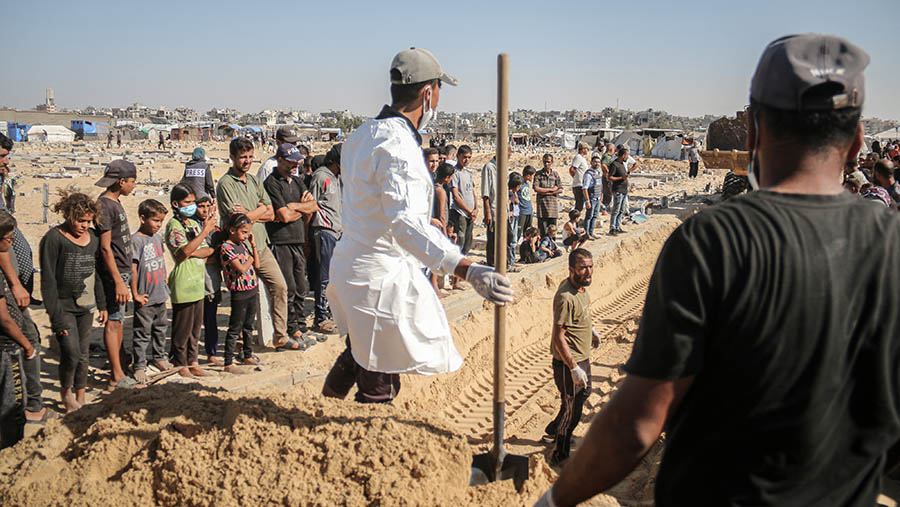 Petugas bersiap memakamkan orang-orang tak dikenal di Khan Younis, Gaza, Kamis (26/9/2024). (Ahmad Salem/Bloomberg)