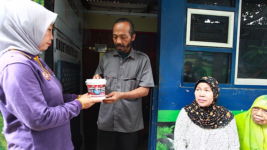 Petugas memberikan ember berisi jentik nyamuk mengandung wolbachia di Kembangan, Jakarta, Jumat (4/10/2024). (Bloomberg Technoz/Andrean Kristianto)