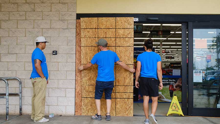 Pekerja menutup tempat usaha sebelum Badai Milton diperkirakan mendarat di St. Petersburg, Florida, AS, Senin (7/10/2024) (Tristan Wheelock/Bloomberg)