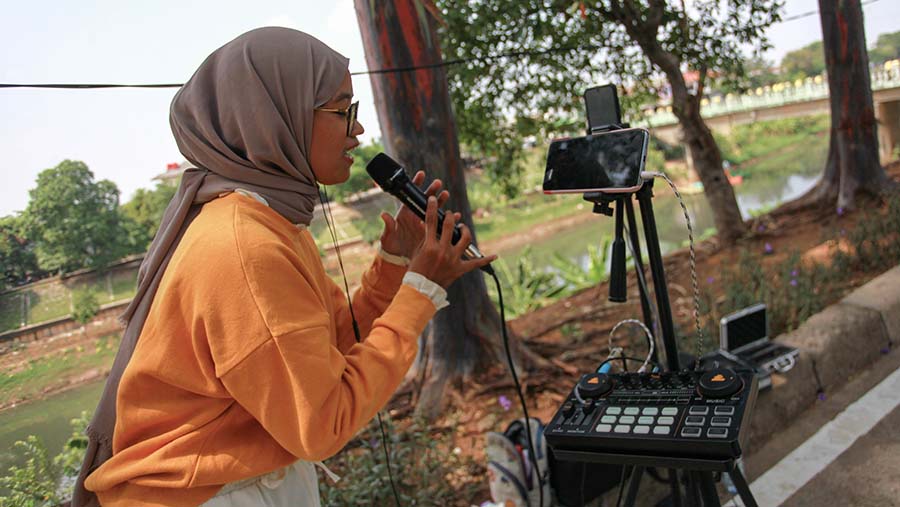 Mereka bernyanyi di depan gawai lengkap beserta microphone dan membawa soundcard (Bloomberg Technoz/Andrean Kristianto)