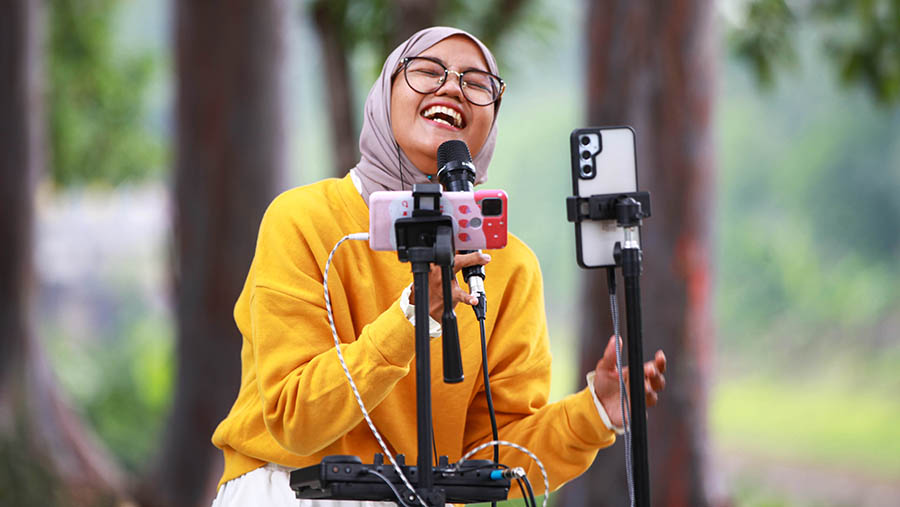 Pembuat konten melakukan live streaming di kawasan Banjir Kanal Timur (BKT), Jakarta Timur, Selasa (9/10/2024). (Bloomberg Technoz/Andrean Kristianto)