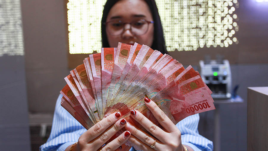 Karyawan menunjukkan uang rupiah di Jakarta, Jumat (11/10/2024). (Bloomberg Technoz/Andrean Kristianto)
