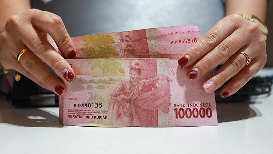 Karyawan merapihkan uang rupiah di Jakarta, Jumat (11/10/2024). (Bloomberg Technoz/Andrean Kristianto)