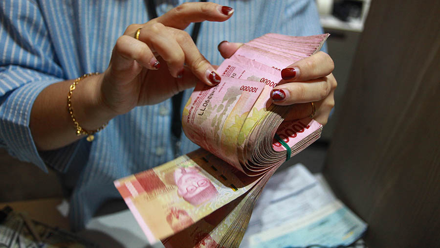 Karyawan menghitung uang rupiah di Jakarta, Jumat (11/10/2024). (Bloomberg Technoz/Andrean Kristianto)