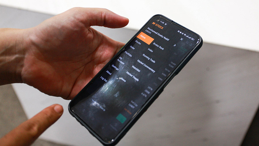 Karyawan membuka aplikasi transaksi saham mobile M-STOCK milik Mirae Asset di Jakarta, Kamis (8/8/2024). (Bloomberg Technoz/Andrean Kristianto)