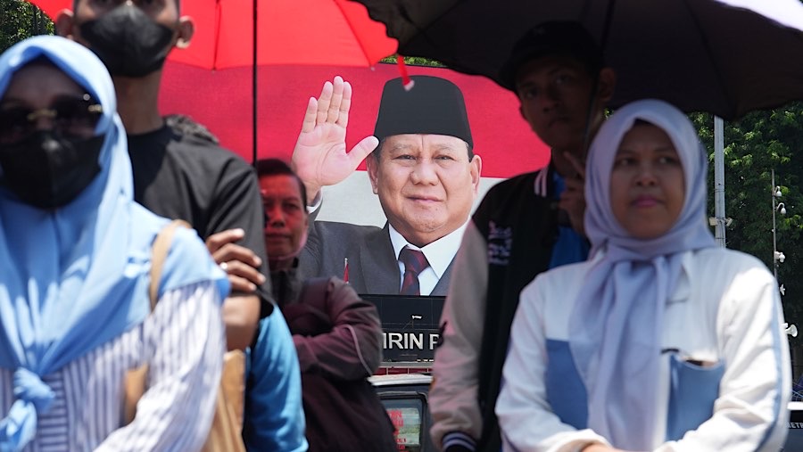 Prabowo menyapa warga yang sudah menunggu sepanjang jalan menuju Istana Negara. (Dimas Ardian/Bloomberg)