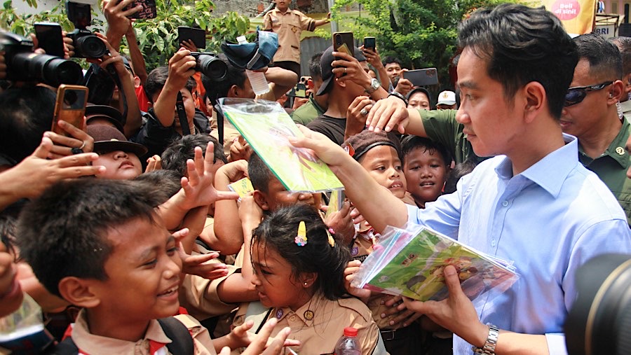 Selain membagikan makanan siang bergizi gratis, Gibran juga memberikan buku tulis. (Bloomberg Technoz/Andrean Kristianto)