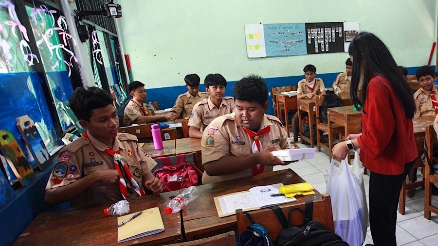 Guru membagikan makan siang bergizi gratis di SMPN 270, Jakarta, Rabu (23/10/2024). (Bloomberg Technoz/Andrean Kristianto)