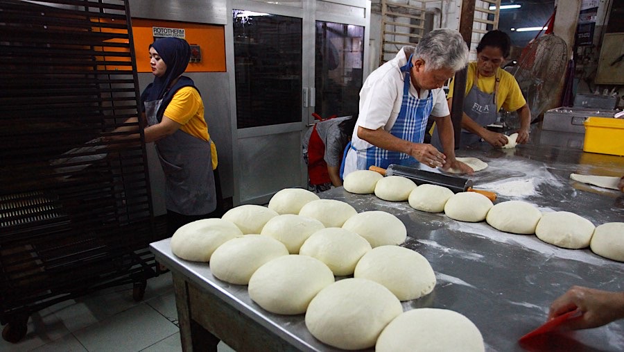 Ridwan Wiryadinata (tengah) menyelesaikan pembuatan roti di Toko Roti Gelora, Jakarta, Senin (4/11/2024). (Bloomberg Technoz/Andrean Kristianto)