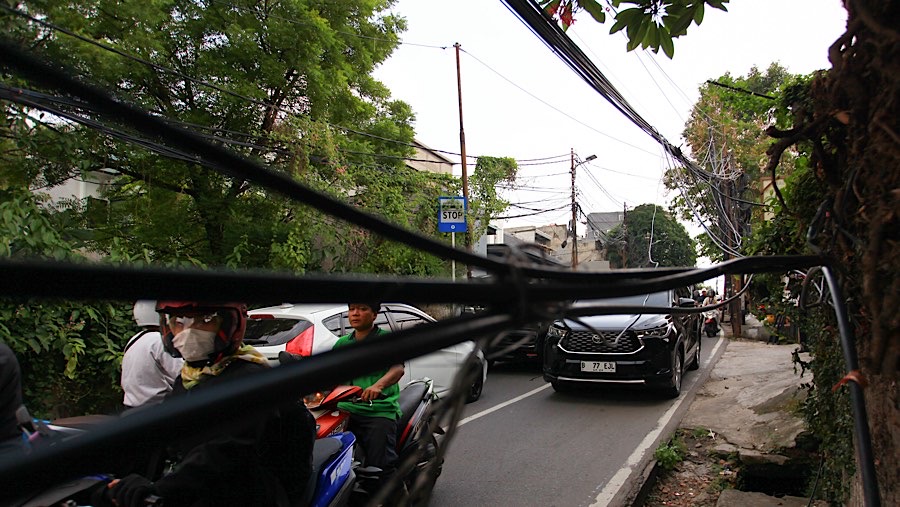 Kabel-kabel yang semrawut dan menggantung di udara sering kali menjadi pemandangan yang mengganggu. (Bloomberg Technoz/Andrean Kristianto)