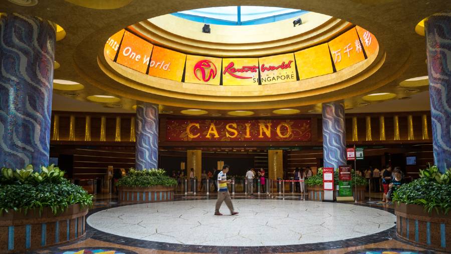 Pengunjung berjalan melewati kasino di Resorts World Sentosa, yang dioperasikan Genting Singapore Plc, di Singapura. (Sanjit Das/Bloomberg)