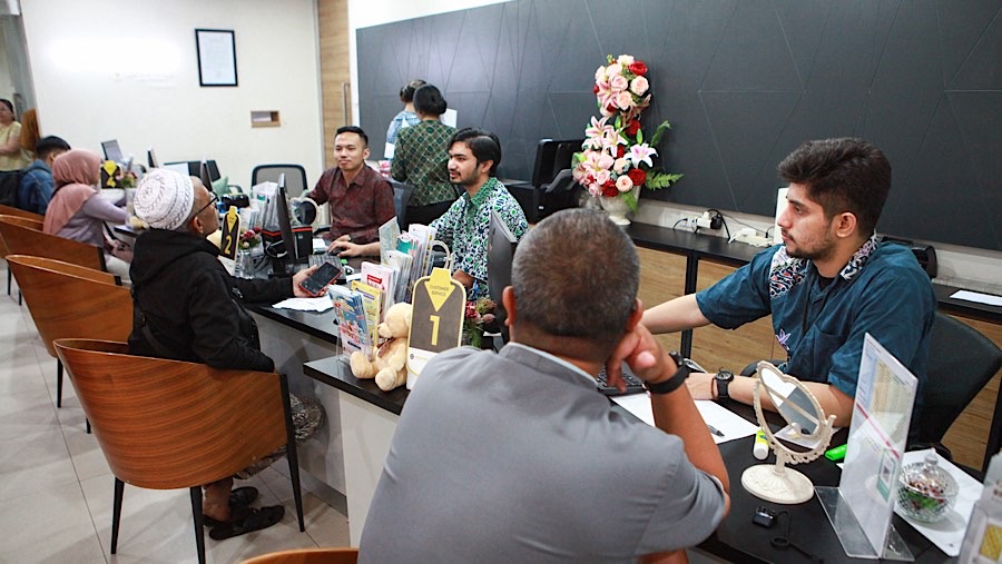 Petugas melayani pengunjung yang ingin bertransaksi di Butik Emas ANTAM, Pulogadung, Rabu (20/11/2024). (Bloomberg Technoz/Andrean Kristianto)