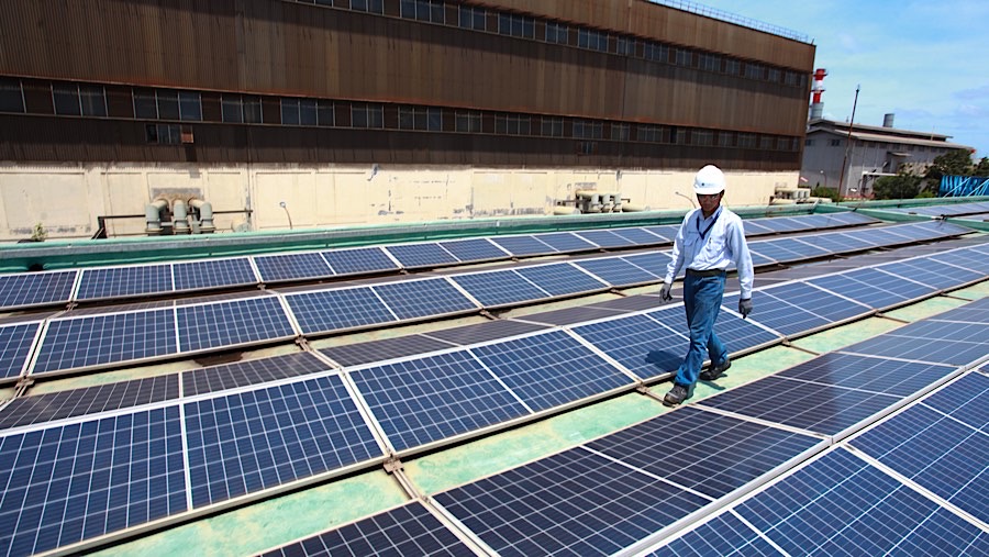 Pekerja mengecek panel surya atas gedung milik Krakatau Chandra Energi di Cilegon, Banten, Selasa (19/11/2024). (Bloomberg Technoz/Andrean Kristianto)