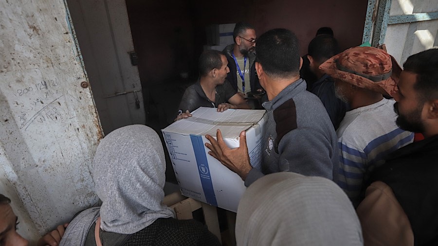 Pengungsi Palestina menerima bantuan kemanusiaan dari Program Pangan Dunia (WFP) di Deir al-Balah, Gaza, Rabu (20/11/2024). (Ahmad Salem/Bloomberg)