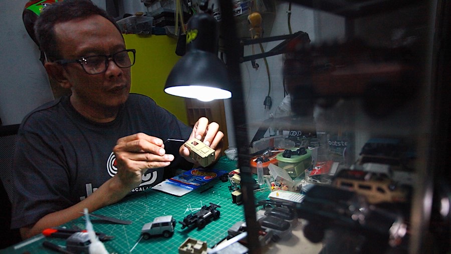 Ade Parlin mengejakan pesanan diecast kustom di workshop DiMana di Pasar Gembrong Baru, Senin (25/11/2024). (Bloomberg Technoz/Andrean Kristianto)