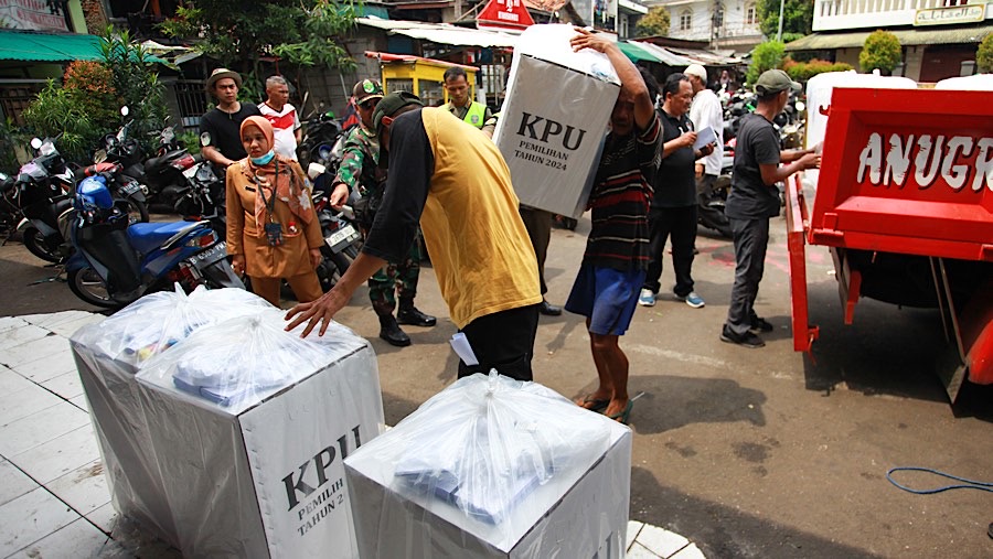 Petugas menurun logistik pilkada untuk dibawa ke kantor RW di kawasan Petamburan, Selasa (26/11/2024), (Bloomberg Technoz/Andrean Kristianto)
